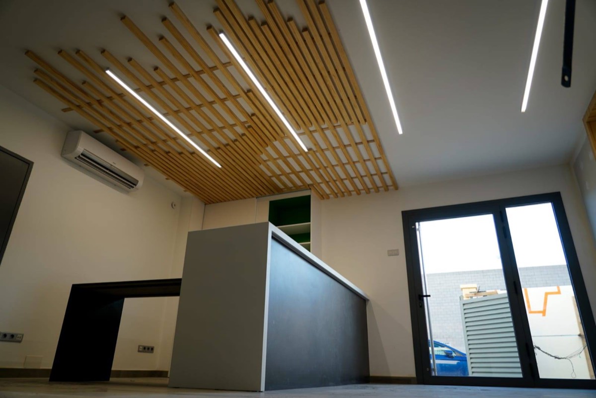 Cocina con iluminación lineal y techo de lamas automatizado